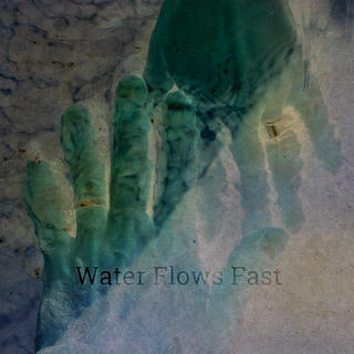 Stylized photo of two hands touching underwater with prominently gleaming wedding bands